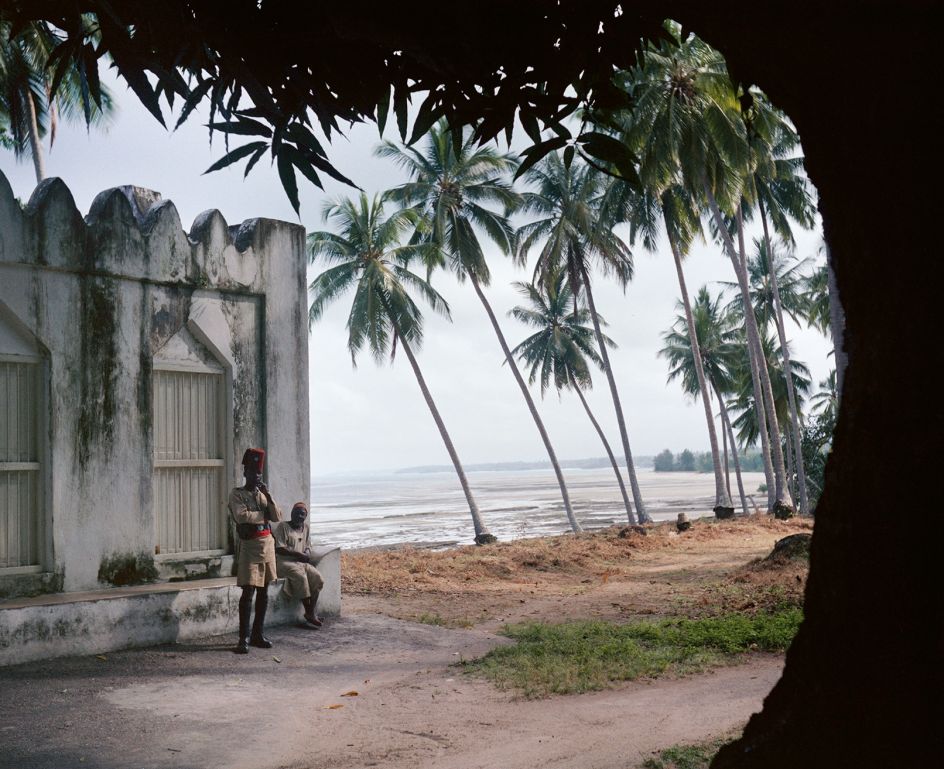 Tanganyika (Tanzania), 1958 – Tanganyika police officer and man next to a wall near the Indian Ocean coastline © 2021 Todd Webb Archive