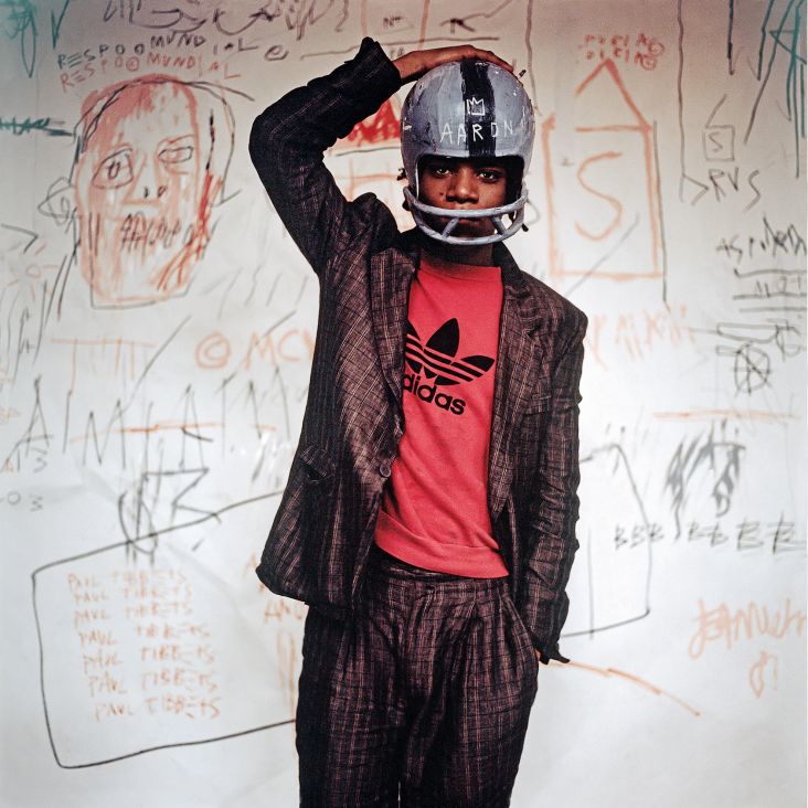 Edo Bertoglio. Jean-Michel Basquiat wearing an American football helmet, 1981 | Photo: © Edo Bertoglio, courtesy of Maripol. Artwork: © The Estate of Jean-Michel Basquiat. Licensed by Artestar, New York