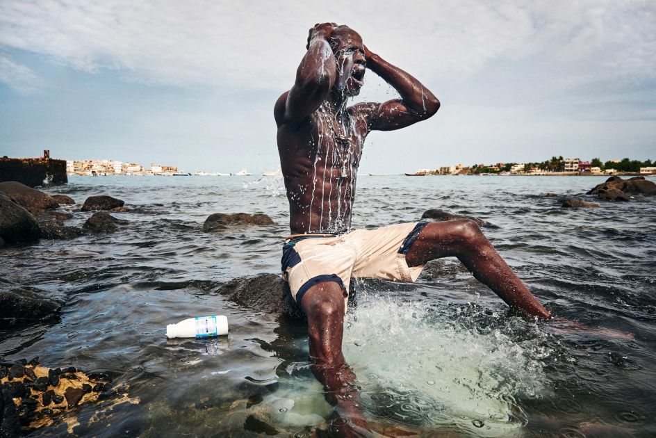 Sports, second prize stories: Kherou, a young wrestling champion, performs a ritual in the water of the sea while pouring milk over his body in order to obtain the reinforcement of a ghost who lives in the stones at the shore. Christian Bobst.