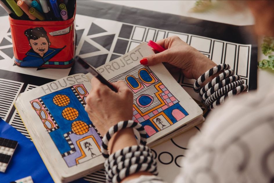 Shot of Camille Walala drawing in her sketchbook at her studio, working on the newly launched installation for LEGO DOTS. Photo credit Dunja Opalko.