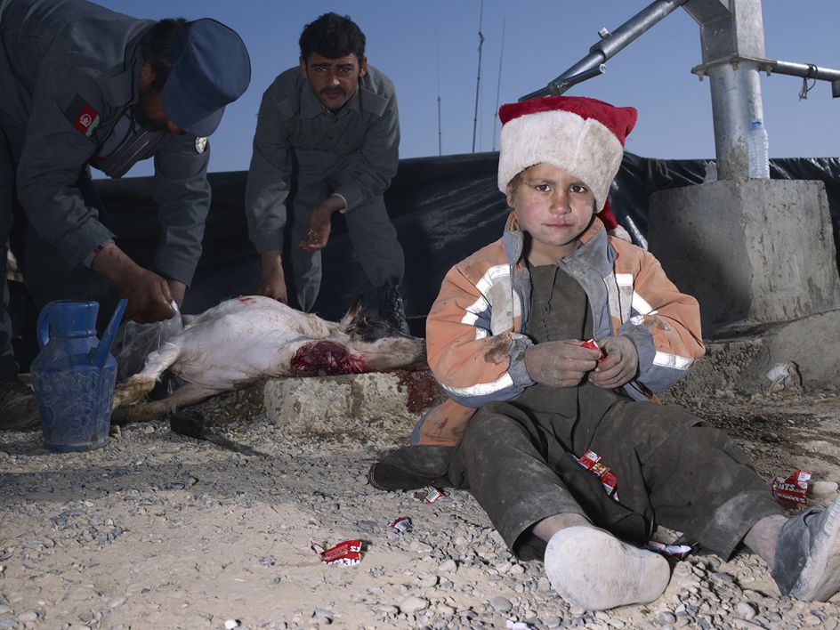Mark Neville, ‘Child, Jacket, Slaughtered Goat, Sweets, Painted Nails, Xmas Day, Helmand’, 2010, courtesy Mark Neville