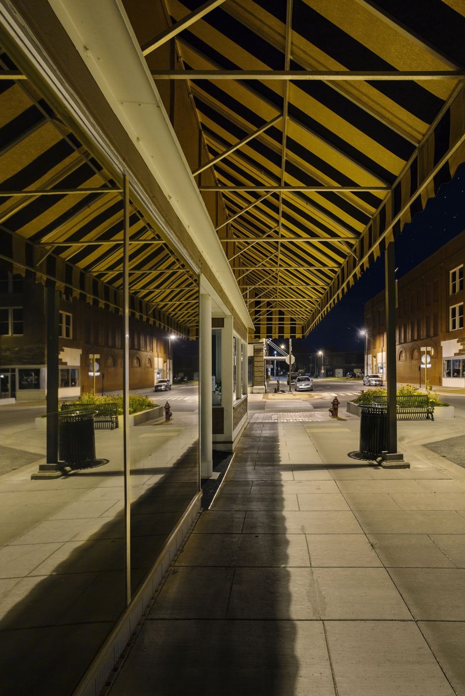 This shop front offers nothing by means of an advertisement for the goods on sale within, but rather reflects itself and its surroundings, bathed in sodium streetlight.