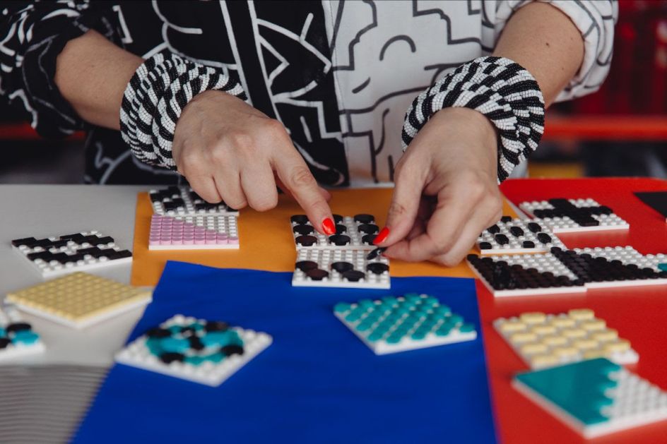 Behind the scenes shot of Camille Walala playing with the new LEGO DOTS range in her studio. Photo credit Dunja Opalko.