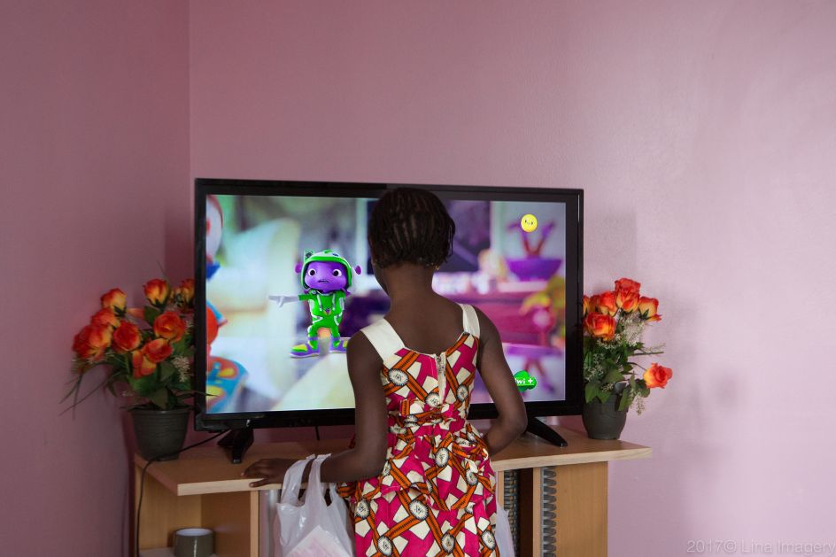 Manchyta watching a cartoon on television. Saint Denis, Ile de France, France From the series ‘First Generation’ © Carolina Arantes