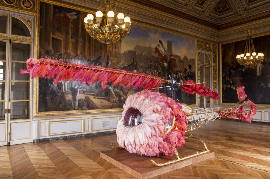 Joana Vasconcelos –  Lilicoptère, 2012 Helicóptero Bell 47, plumas de avestruz, cristales de Swarovski, pan de oro, pintura industrial, tapizado de cuero teñido repujado en oro fino, alfombras de Arraiolos, madera de nogal, pintura efecto madera y pasamanería 300 x 274 x 1265 cm Colección particular