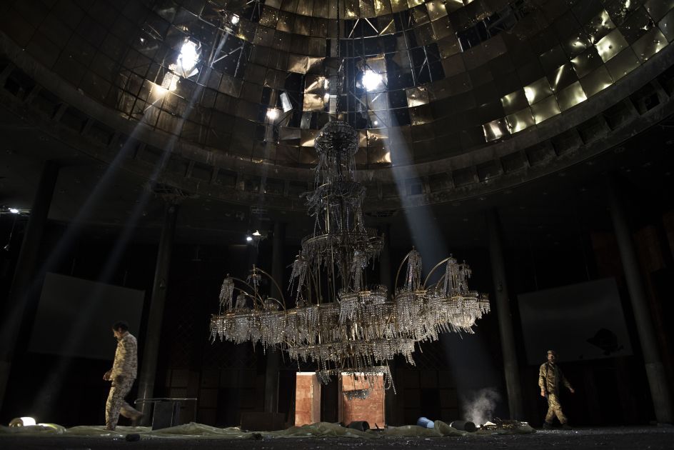 Libya, July 14, 2016: Fighters of the Libyan forces affiliated with the Tripoli government walk around the gigantic chandelier of the conference room in the Ouagadougou conference centre | © Alessio Romenzi, Italy, Shortlist, Professional, Current Affairs & News, 2017 Sony World Photography Awards
