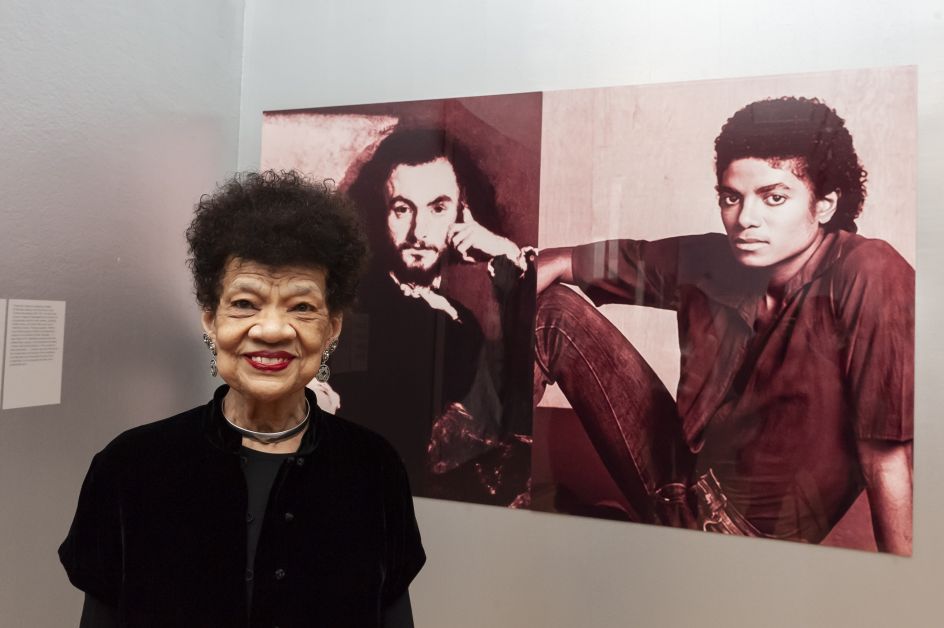 Lorraine O'Grady with her work, The First and Last of the Modernists, Diptych 1 Red (Charles and Michael) 2010. Photograph by Jorge Herrera