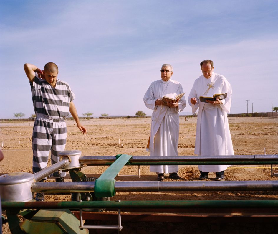 An inmate and two priests during burial duty