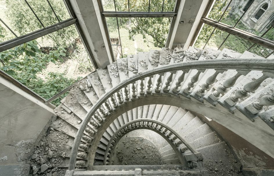 A crumbling spiraling staircase is seen inside this former Soviet sanatorium. Tskaltubo, Georgia. © Reginald Van de Velde