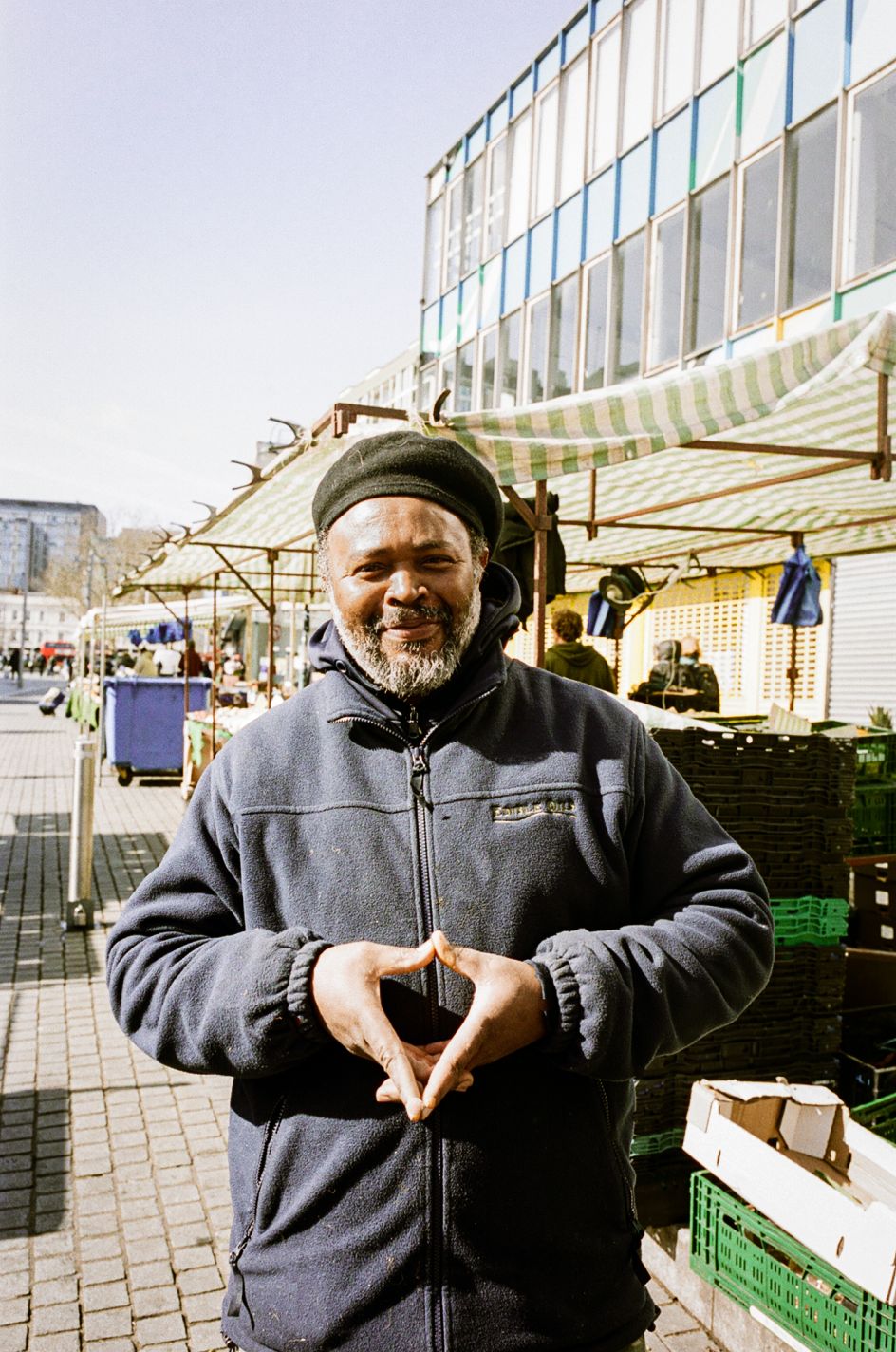 Junior in front of Junior's Caribbean stall in Woolwich © Jonas Martinez / Museum of London
