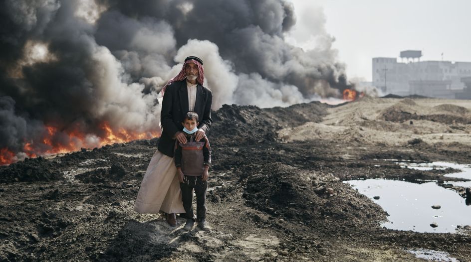 Kharim and his guardian, Nadak, beside a burning oil field. Qayyarah, Nineveh Governorate, Iraq, October 25, 2016. From [We Came From Fire​](​https://amzn.to/2L9l8Vm) by Joey L. – published by powerHouse Books