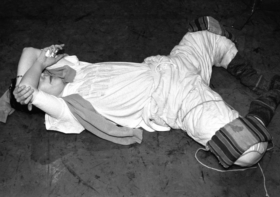 A dancer with weights on her knees, stretching at class, 1960s. Copyright Colin Jones / Topfoto.co.uk