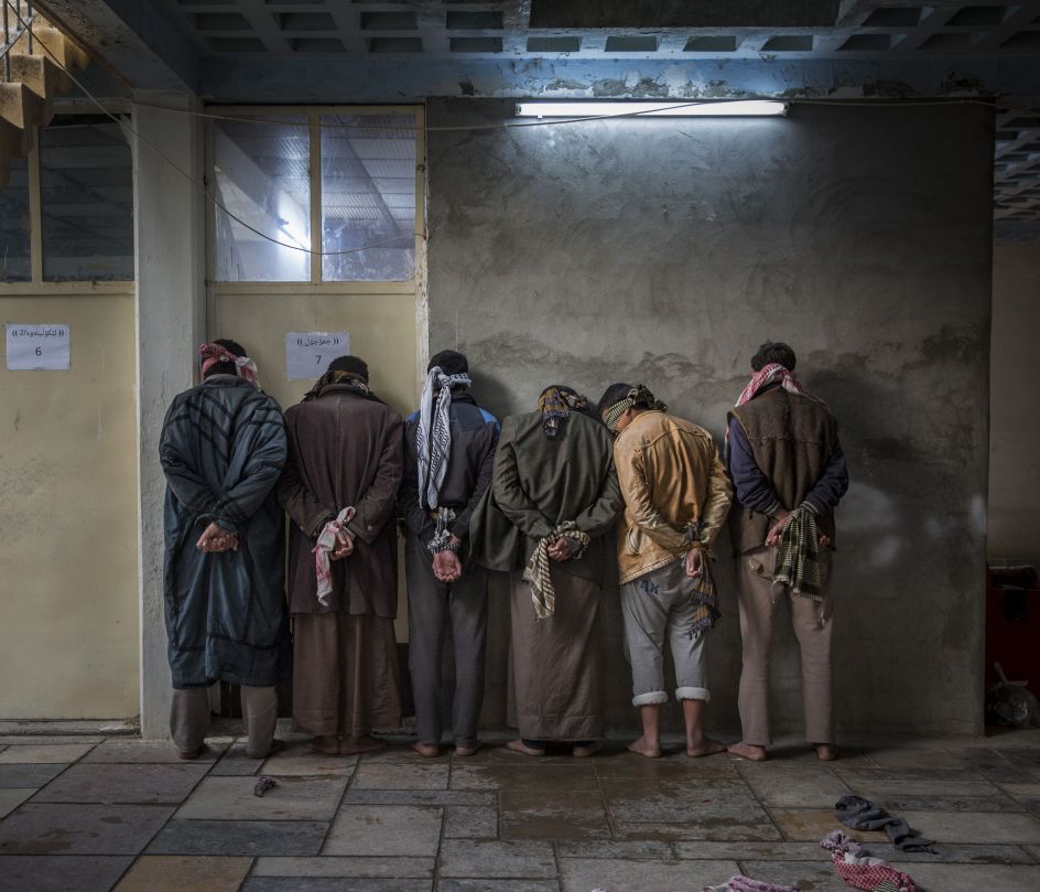 Iraqi men from the Hawija region of Iraq wait to be questioned by Kurdish security personnel at a base near Kirkuk. Having fled areas still under the control of ISIS militants, men and boys of fighting age are vetted for any links to the group before being allowed to join their families in camps for displaced people in the Kurdish controlled region of the country | © Ivor Prickett, Ireland, Shortlist, Professional, Current Affairs & News, 2017 Sony World Photography Awards