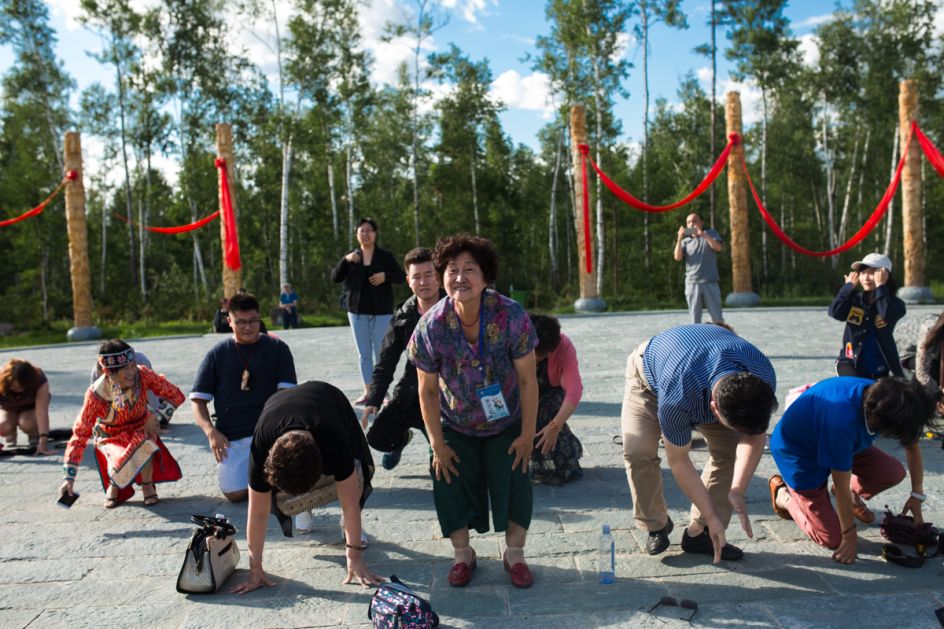 Lower Kingan Mountain Range, Heilongjiang Province, July 2017 Community leader Guan Jinfang leads visiting government representatives in a ritual praying for fortune from a newly constructed monument to shamanism.