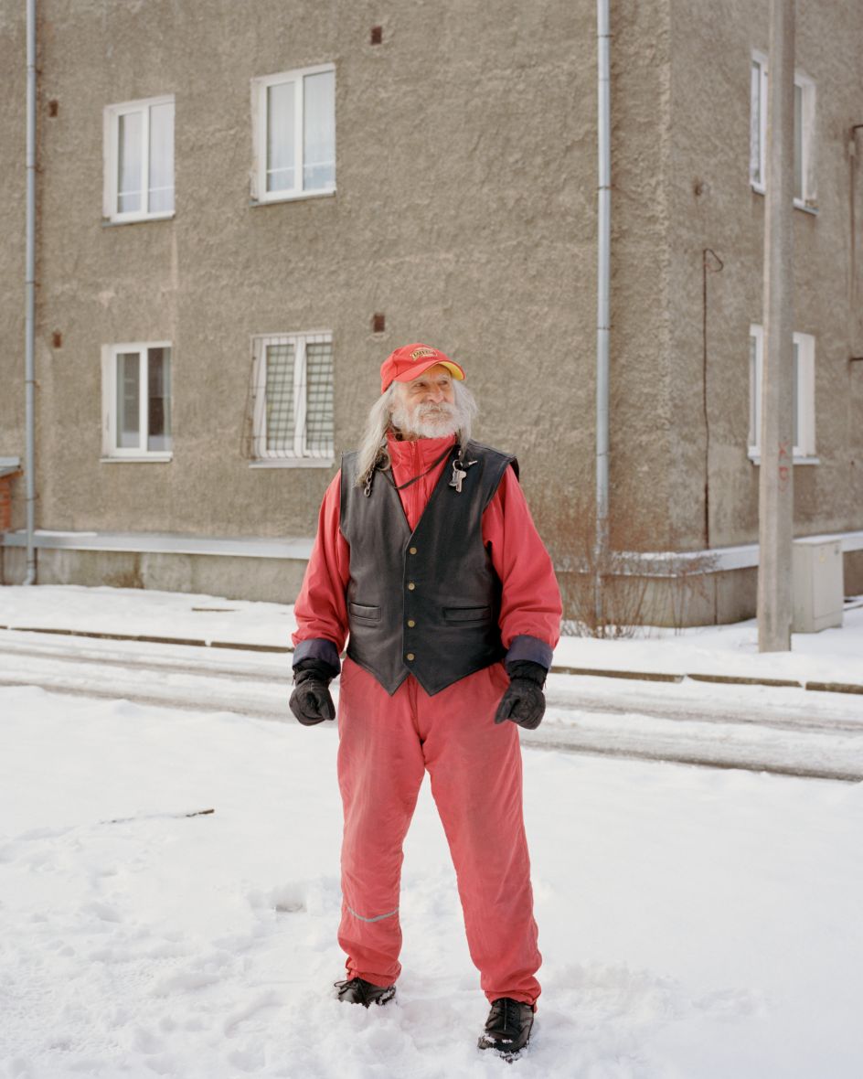 Vladimir while feeding the pigeons in front of his apartment block, Narva, Estonia, 2018 © Miguel Proença