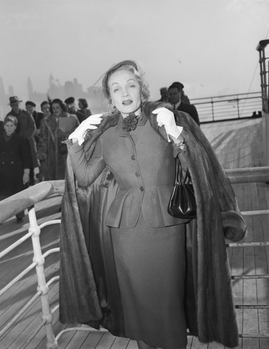 Marlene Dietrich wearing a day suit by Christian Dior on-board the Queen Elizabeth arriving in New York 21 December 1950 © Getty Images