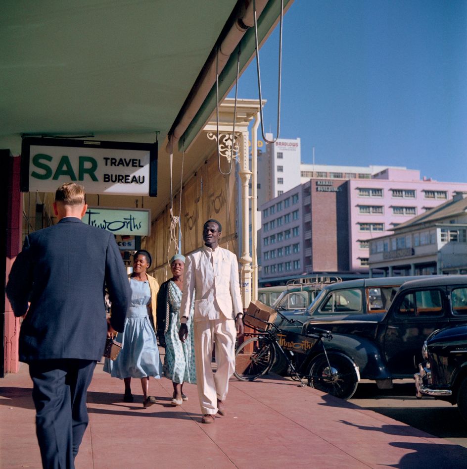 Southern Rhodesia (Zimbabwe), 1958 – Pedestrians walking past SAR Travel Bureau, Truworths, and other shops, Bulawayo © 2021 Todd Webb Archive