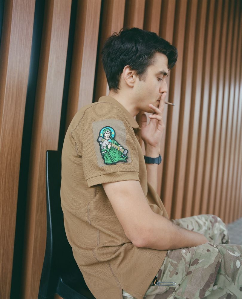 Tymur A., a 26 y.o. tech project manager who volunteered to join the Armed Forces of Ukraine as a platoon commander. He is pictured at a gas station in Vinnytsia, Ukraine, wearing a Saint Javelin patch. 2022 © Ira Lupu