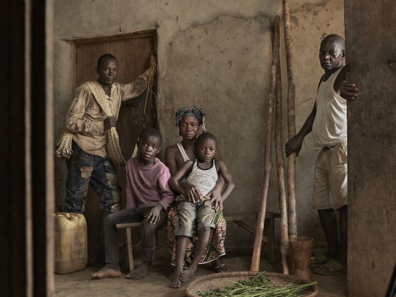 Joe, 6, sitting on the lap of Mariatu, his mother, with the rest of the family posing for a group portrait, at their home in the village of Tombohuaun, Kailahun District, Sierra Leone, May 2017. WaterAid/ Joey Lawrence