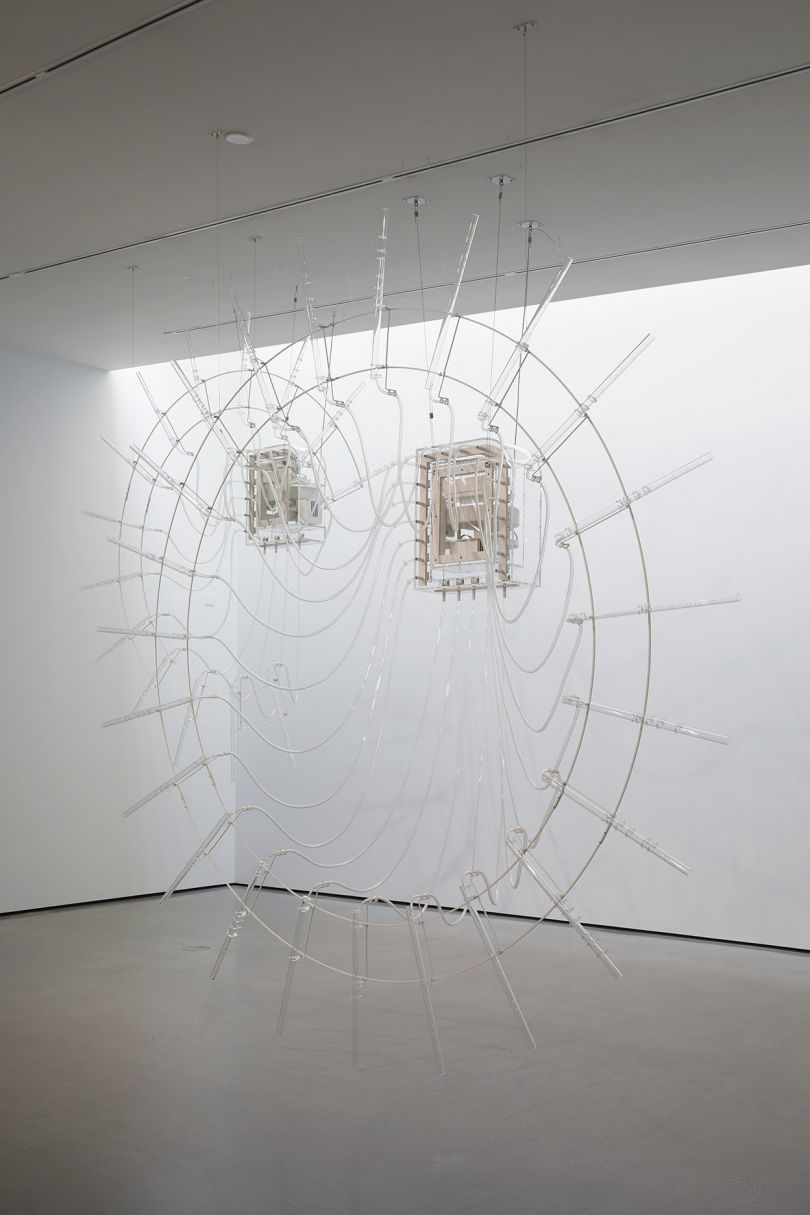 Installation shot of Cerith Wyn Evans in The Hepworth Prize for Sculpture. 26 October 2018 - 20 January 2019. Photo, Stuart Whipps Composition for 37 flutes (in two parts), 2018, 37 crystal glass flutes, ‘breathing’ unit and valve system, plastic tubes.