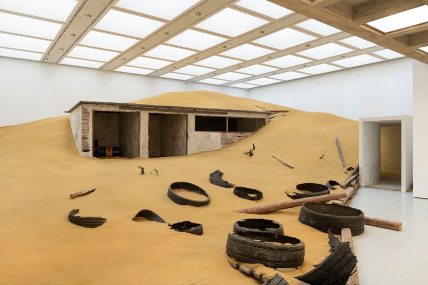Installation view of Mike Nelson, Triple Bluff Canyon (the woodshed), 2004. Various materials. M25, 2023. Found tyres. Photo: Matt Greenwood. Courtesy the artist and the Hayward Gallery