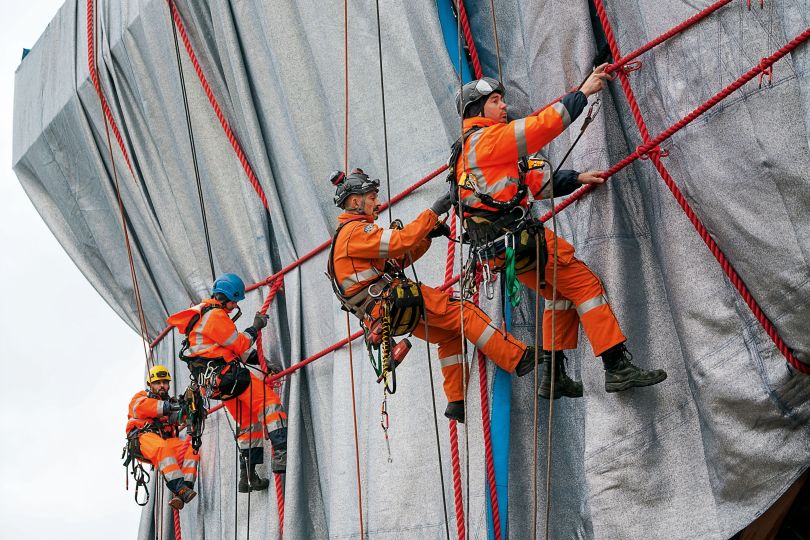 Professional climbers from Compagnie des Guides de Chamonix link the ropes to steel rope connectors, which are attached through “button holes” in the fabric to the steel structure.