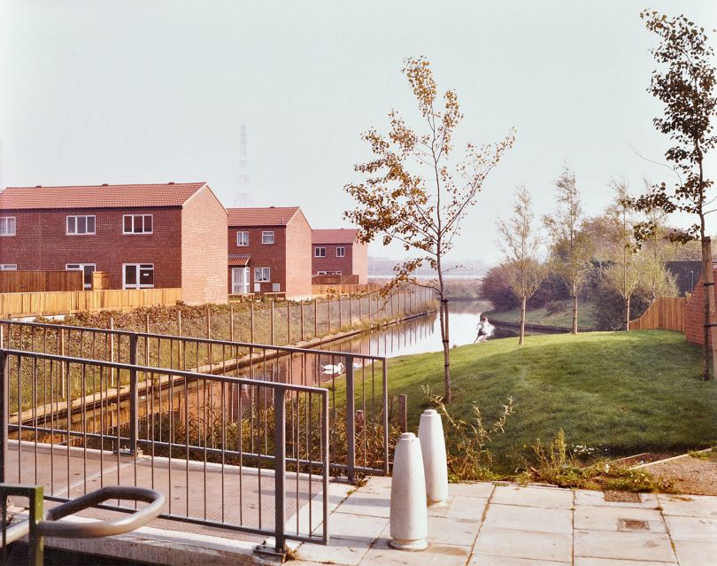Manordene Road, off Crossway, Area 5, looking north east along the waterway that runs from Moat Gardens to Tump 39 and the Thamesmead Ecology Study Area. 1982 © London Metropolitan Archives