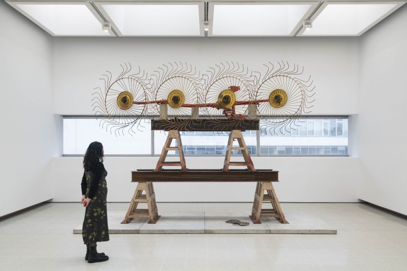Installation view of Mike Nelson, The Asset Strippers (solstice), 2019. Hay rake, steel trestles, steel girders, sheet of steel, cast concrete slabs. Photo: Matt Greenwood. Courtesy the artist and the Hayward Gallery