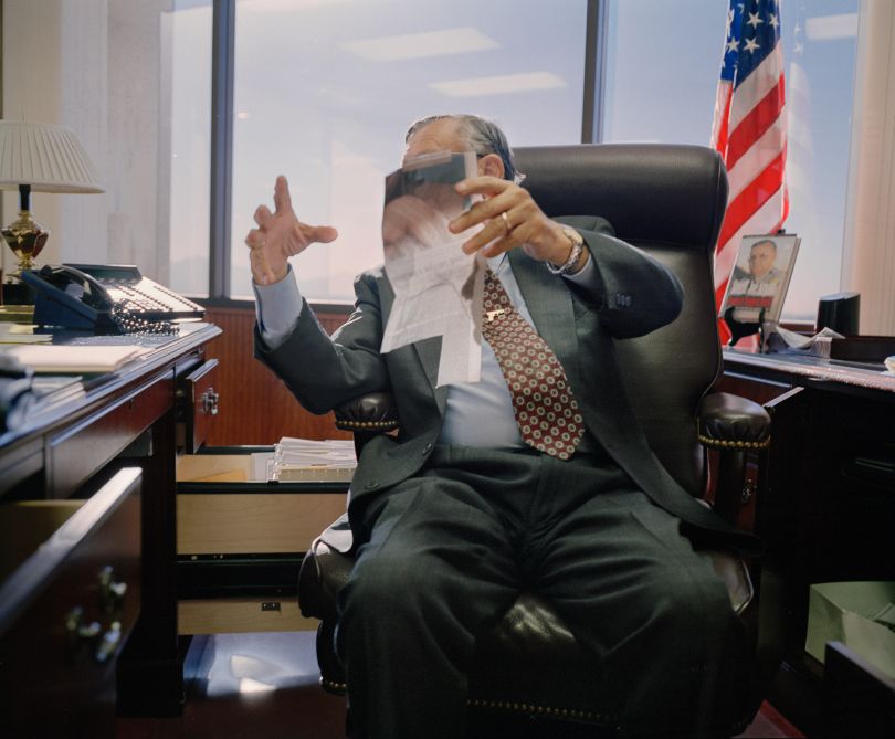 Sheriff Joe Arpaio shows a newspaper clipping about himself to a writer during an interview in his office in Phoenix