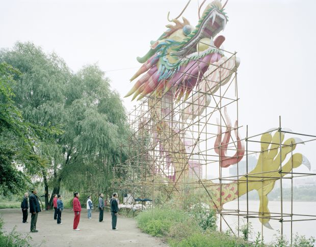 People doing morning exercise in front of a dragon lam, Gansu, 2011 © Zhang Kechun