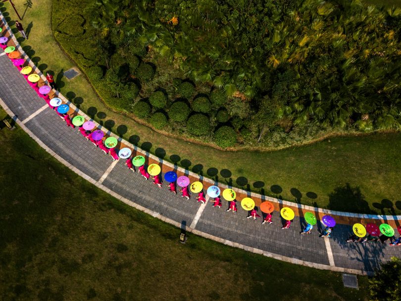 New flowers in the garden: On October 29, 2017, the local cultural group held a cheongsam show at the national park in Guigong City, Guangxi Province, China. From the perspective of an aerial photography it looks like a wonderful new kind of flowers.  Copyright: © Shifang Lin, China, Shortlist, Open, Culture (Open competition), 2018 Sony World Photography Awards