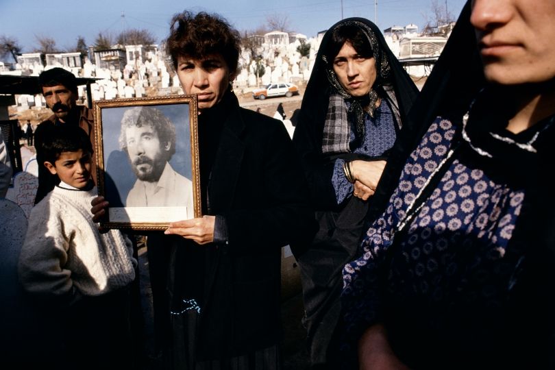 Photographs of 20-year-old Kamaran Abdullah Saber are held by his family at Saiwan Hill cemetery. He was killed in July 1991 during a student demonstration against Saddam Hussein, Kurdistan, Northern Iraq, 1991 © Susan Meiselas