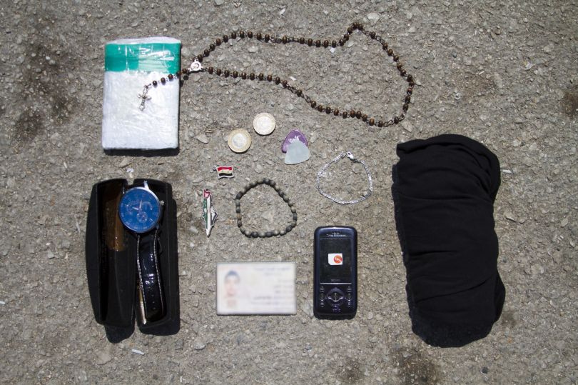 A rosary, a watch, guitar picks, cell phone
